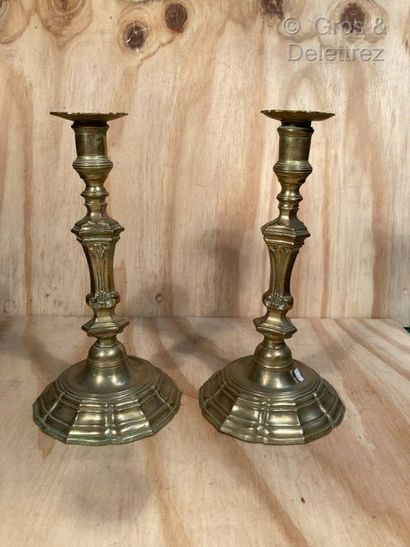 null Pair of brass candleholders with wide contoured base, the was decorated with...