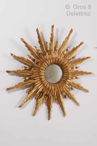 null Miroir sorcière en bois sculpté et doré à décor rayonnant.

Vers 1950.

Diam....