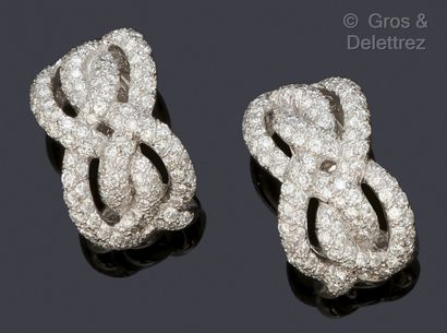 null A pair of white gold "Smyrna" ear clips with intertwined ribbons forming crosses...