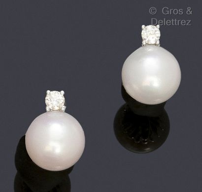 null Pair of earrings, each adorned with a cultured pearl topped by a brilliant-cut...