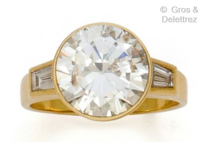 null Yellow gold "Solitaire" ring set with a brilliant-cut diamond and two trapeze...