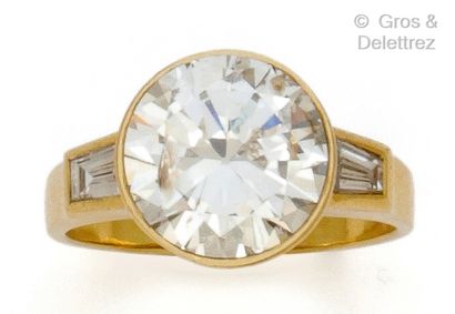 null Bague « Solitaire » en or jaune, ornée d’un diamant taillé en brillant épaulé...