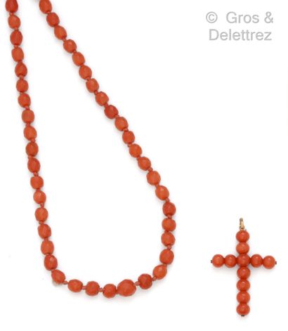  Necklace composed of a fall of faceted coral pearls, holding a cross pendant composed...