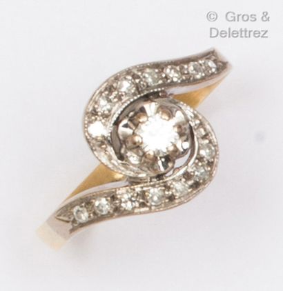  Yellow and white gold ring with scrollwork, set with a brilliant-cut diamond in...