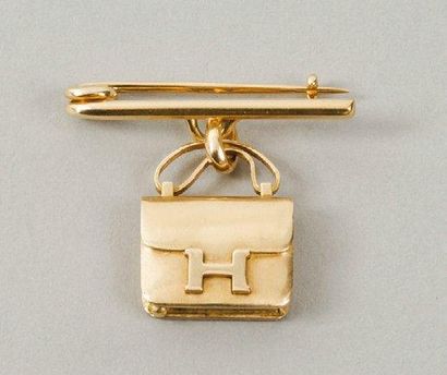 HERMES Paris Epingle à nourrice en or agrémentée d'un charms figurant le sac «Constance»....