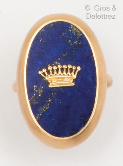 null Bague en or jaune, ornée d’une plaque de lapis-lazuli surmontée d’une couronne...