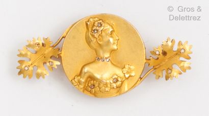null Broche en or jaune, ornée d’une médaille figurant une femme habillée et coiffée...