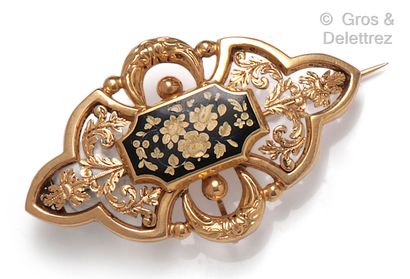 null A yellow gold polylobed brooch partially enamelled in black with a flower design...