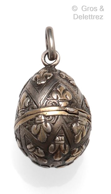  Yellow gold and silver pendant, forming an egg chased with a fleur-de-lis. Length:...