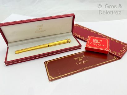 CARTIER « Trinity » − Stylo plume en métal plaqué or, la plume en or. Dans son écrin...