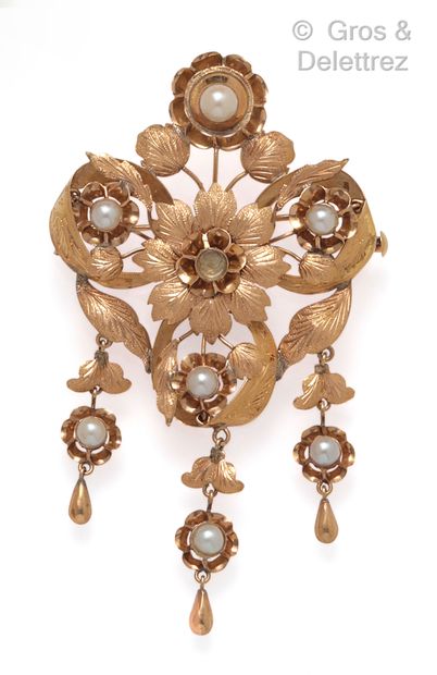 null A yellow gold brooch with flowers and foliage set with pearls, three of which...