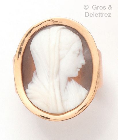 A yellow gold ring with a shell cameo showing...
