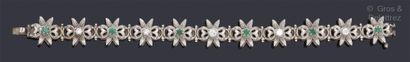 null Bracelet souple en or gris à décor de fleur ciselées agrémentées d’émeraudes...