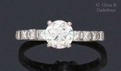 null Bague « Solitaire » en or gris, ornée d’un diamant taillé en brillant épaulé...