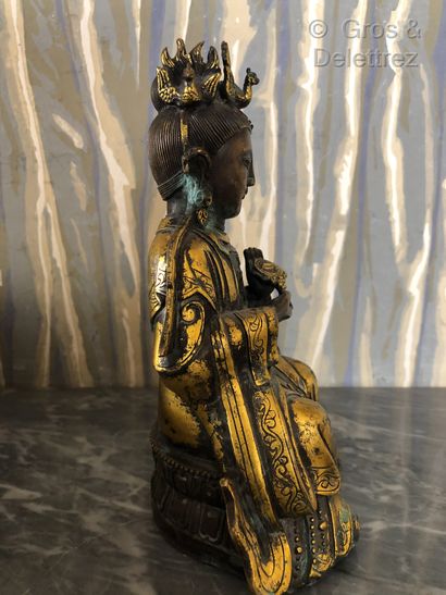null Chine. Divinité bouddhique en bronze doré en position assis sur un socle godronné...