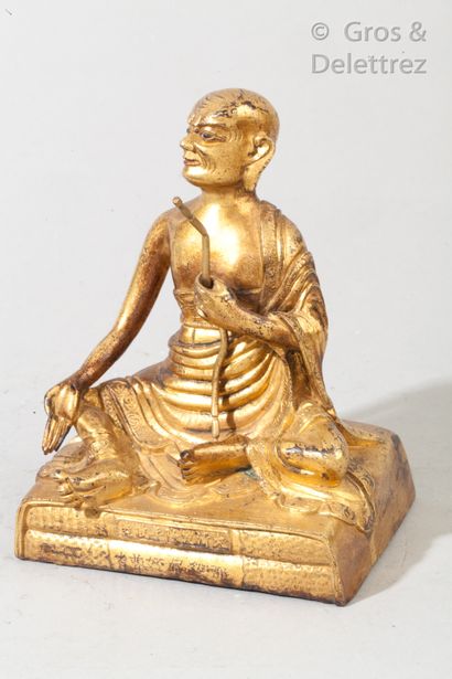null Divinité bouddhique en bronze doré assis en délassement tenant dans sa main...