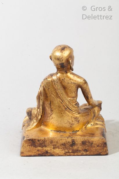 null Divinité bouddhique en bronze doré assis en délassement tenant dans sa main...