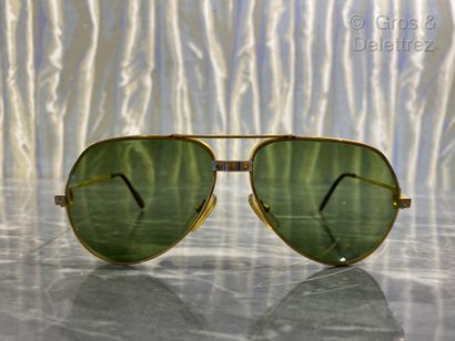 null Cartier. Pair of aviator glasses in gilded metal and burgundy branches. The...