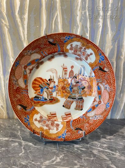 null Japon. Assiette en porcelaine à décor polychrome de deux samouraï, l'un à genou...