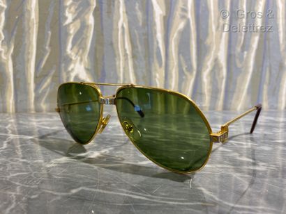 null Cartier. Pair of aviator glasses in gilded metal and burgundy branches. The...