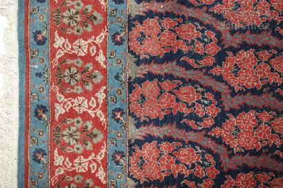 null Iranian carpet decorated with a series of botehs in blue and red tones.

216...