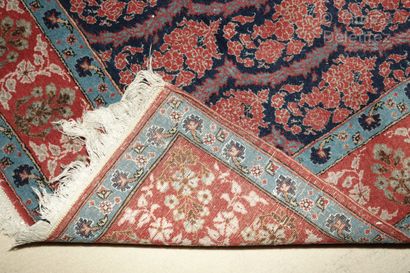 null Iranian carpet decorated with a series of botehs in blue and red tones.

216...