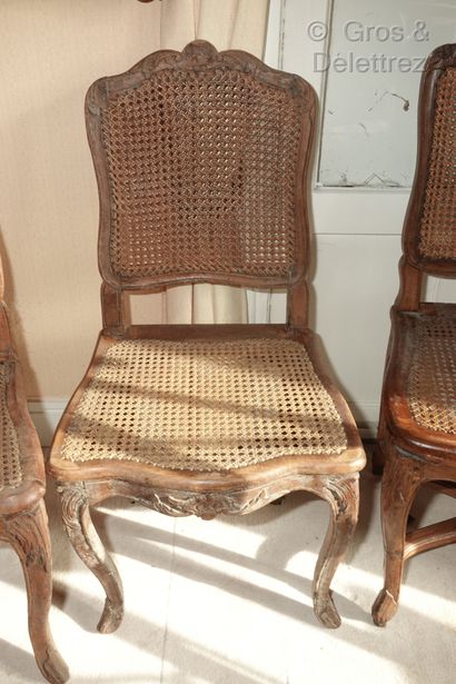 null A set of four caned chairs in natural wood, moulded and carved with flowers...