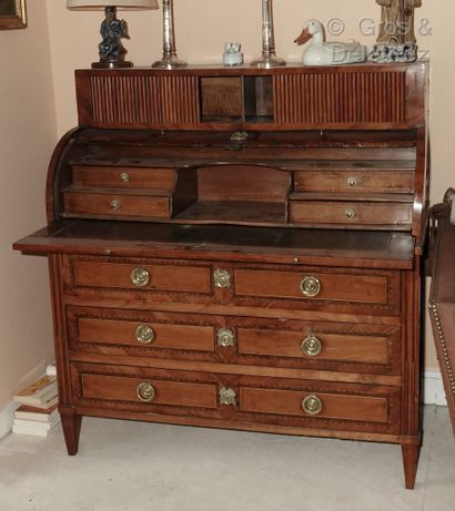 null A scriban chest of drawers forming a cylinder desk, made of veneered wood inlaid...