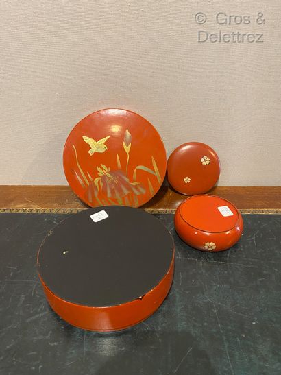 null Japan. Two red lacquered wood boxes, one circular with gold decoration of a...
