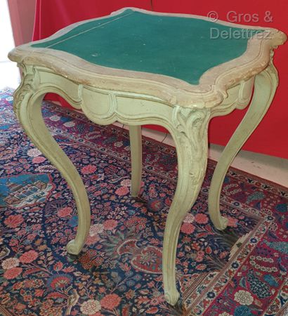 null A grey lacquered wood table, moulded and carved with foliage, the legs arched.

Louis...