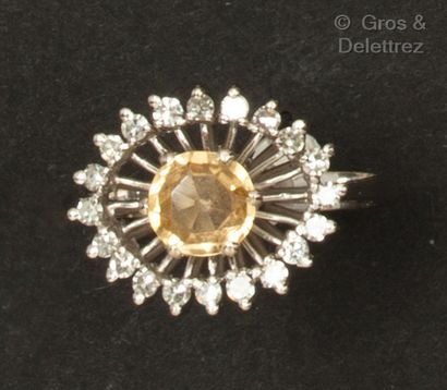 A white gold ring set with a round orange...