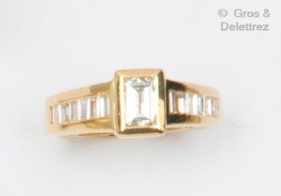 null Bague en or jaune, ornée d’un diamant baguette en serti clos, épaulé d’une chute...