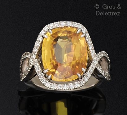 A white gold ring set with a yellow sapphire...