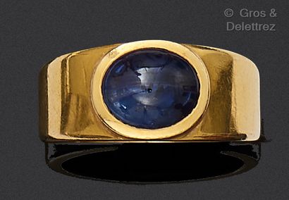 Yellow gold ring, set with a blue cabochon...