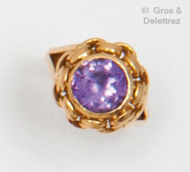 null Yellow gold ring with braided decoration, set with a round facetted amethyst....