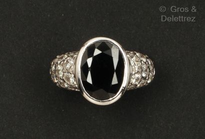 A white gold ring set with an oval sapphire...