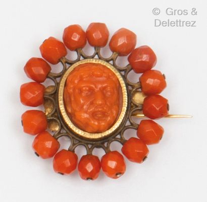 null A yellow gold and metal brooch with a cameo on coral representing the face of...