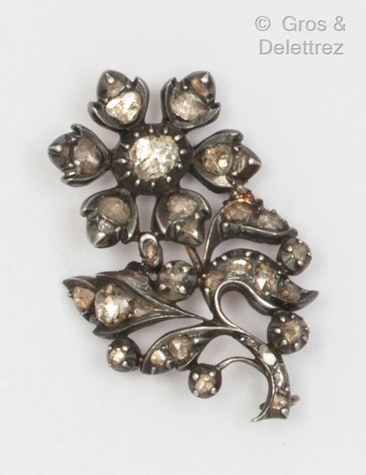 A yellow gold and silver brooch with a flower...
