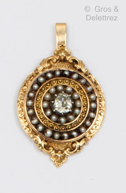 null A yellow gold pendant with a pear-shaped diamond set in a double circle of grey...