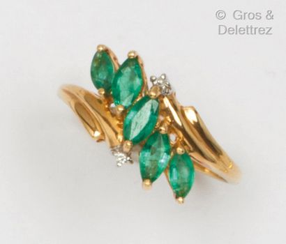  Yellow gold ring set with navette emeralds and two brilliant-cut diamonds. Finger...