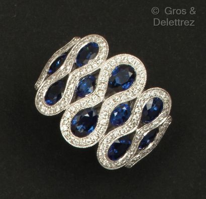 null A white gold ring set with oval sapphires in sinuous settings of brilliant-cut...