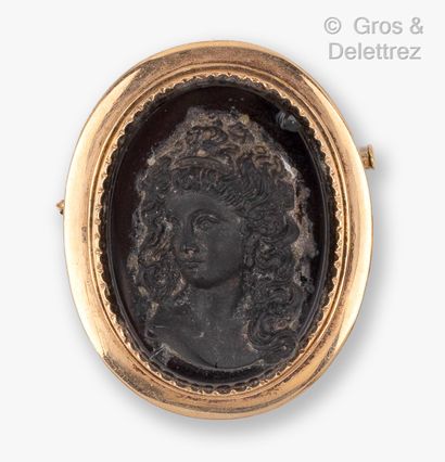 null A yellow gold brooch with a high relief representing the bust of a woman on...