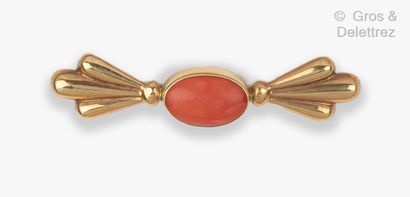 null Barette" brooch in yellow gold, set with a coral cabochon with gadrooned palmettes....