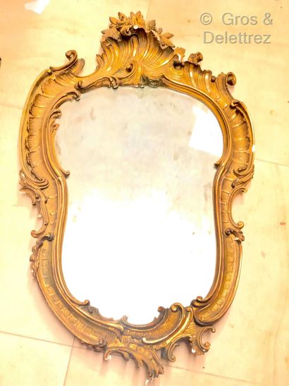 Miroir en bois stuqué doré de forme violonée...