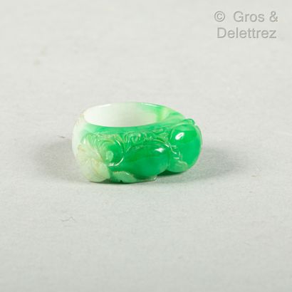 null China, 20th century

Small green-infused jadeite ring carved with a coloqui...