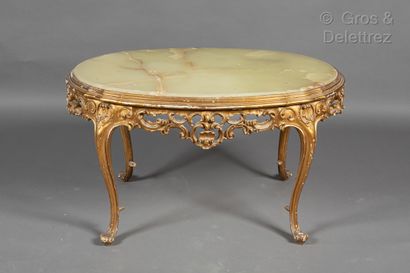  Small oval table in carved and gilded wood resting on four curved legs ending in...