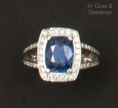 null White gold ring, set with a cushion sapphire surrounded and shouldered by brilliant-cut...