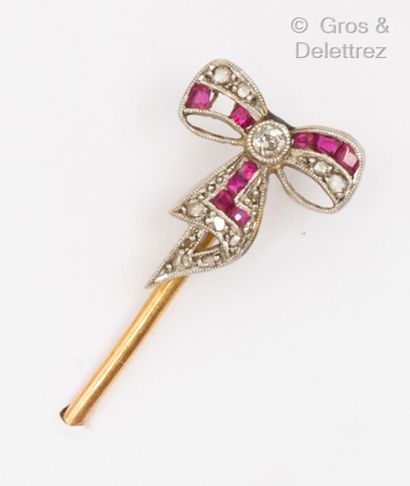 null Yellow gold tie pin set with a diamond and red stone bow. Gross weight: 3.9...