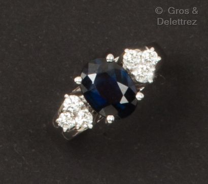 null Bague en or gris, ornée d’un saphir épaulé de diamants taillés en brillant....