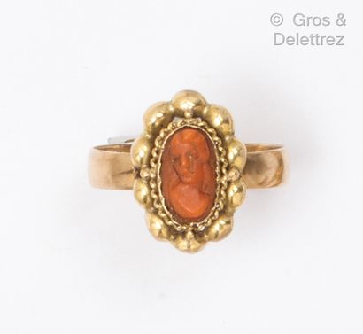 Yellow gold ring, with a cameo on coral representing...